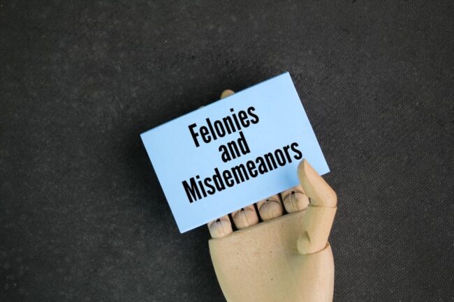 What Are the Differences Between Misdemeanors and Felonies in Michigan Paper with the words Felonies and Misdemeanors. typically defined as a crime punishable by a term of imprisonment of one year or more