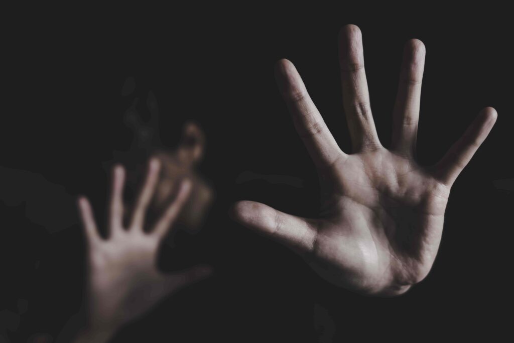 Person raising hands in defense, symbolizing fear, abuse, or domestic violence prevention. Person raising hands in defense, symbolizing fear, abuse, or domestic violence prevention.