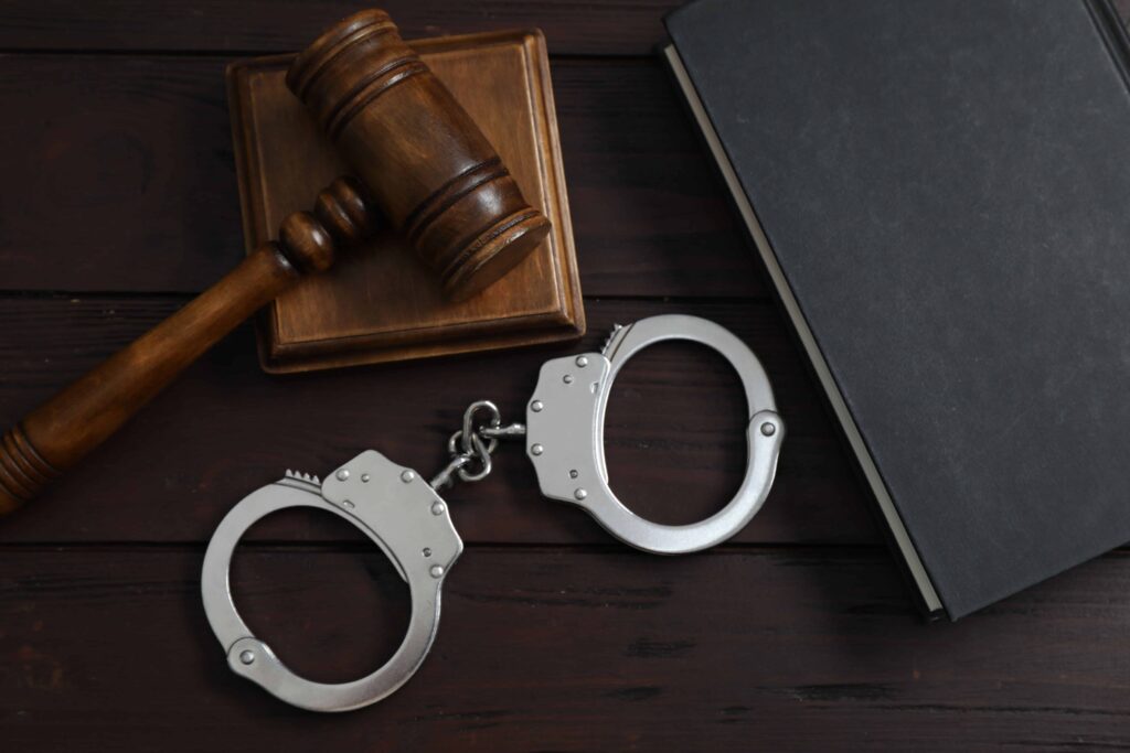 Judge’s gavel, handcuffs, and law book symbolizing criminal justice and legal defense. Judge’s gavel, handcuffs, and law book symbolizing criminal justice and legal defense.