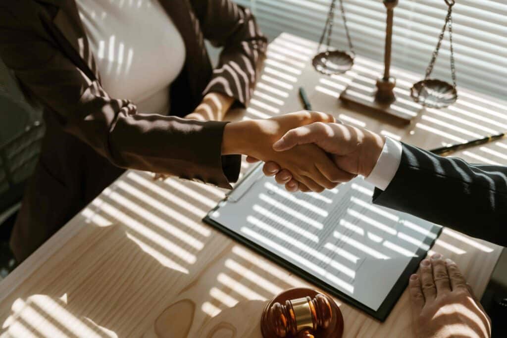 Lawyer and client shaking hands after successful legal consultation in office. Lawyer and client shaking hands after successful legal consultation in office.