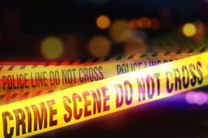 Yellow Tape Showing Text "Crime Scene do not cross" Restricting a Crime Scene Area At Night. 