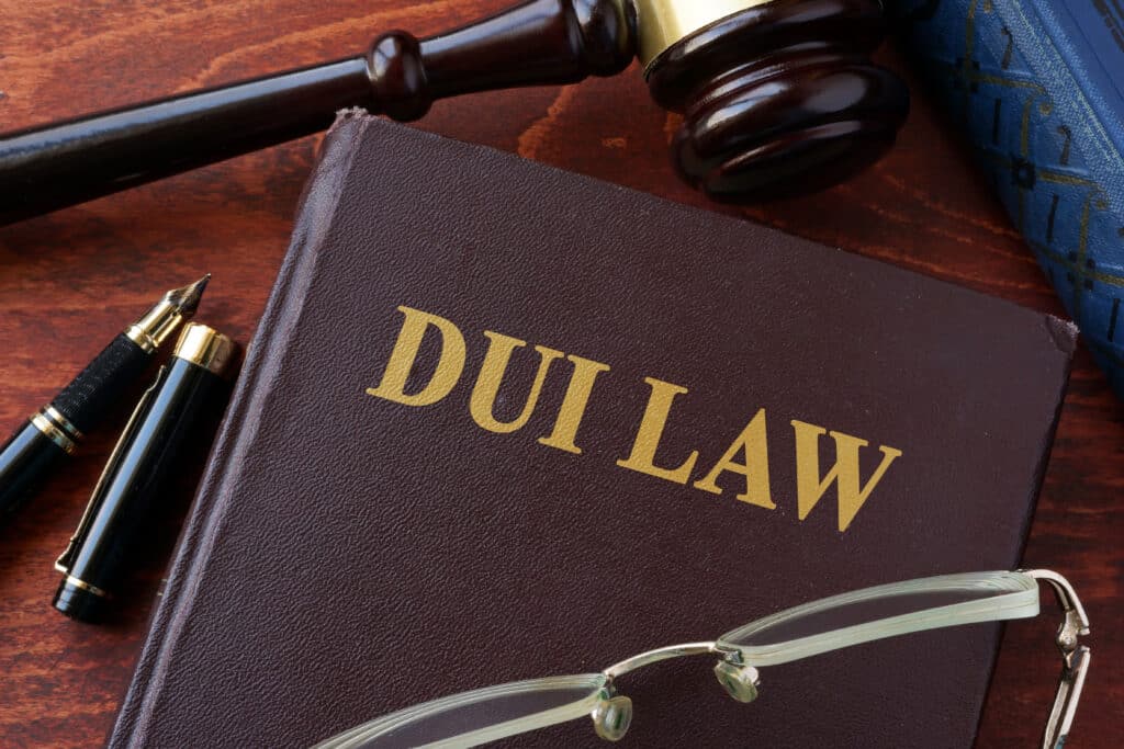 DUI law book with gavel, pen, and glasses on lawyer’s desk.